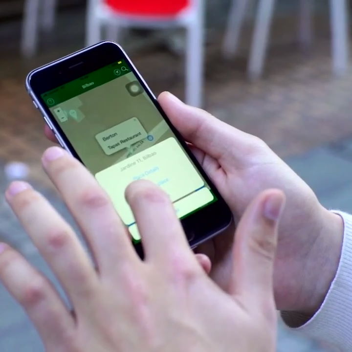 Image of a hand holding a mobile phone with the Access Earth app being displayed